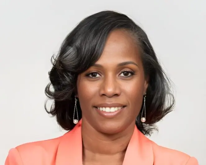 Professional woman with styled hair and peach blazer.