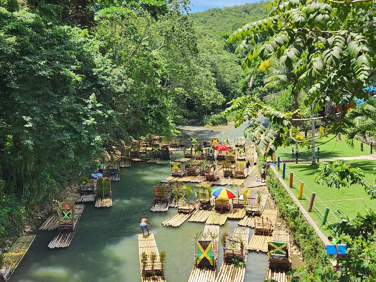 People relaxing on bamboo rafts in a lush river gorge.