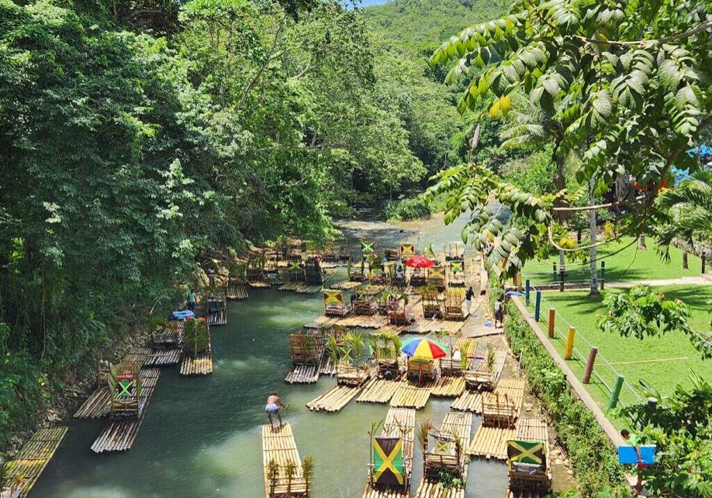 People relaxing on bamboo rafts in a lush river gorge.