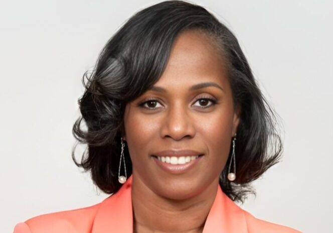 Professional woman with styled hair and peach blazer.